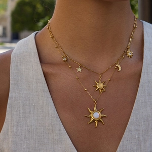 Dettaglio della collana a strati in oro 18K con ciondoli a sole e luna e pietra opale