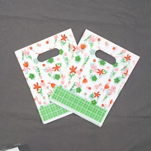 Detail of floral plastic gift bag with green plaid base and oval die-cut handle