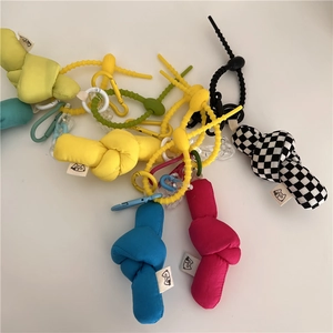 Detailed pile of colorful checkered fabric doll charms with plastic carabiner hooks