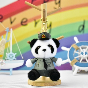 Detailweergave van een pluche panda-sleutelhanger in grijs politie-uniform