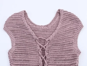 Detailed macro view of the V-neck crisscross tie design on a textured knit vest