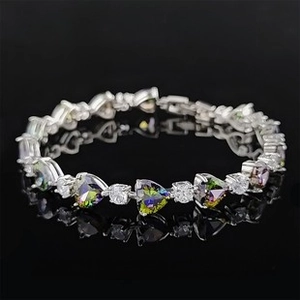 Detailed macro view of heart-shaped rainbow gemstones and white diamonds on a silver bracelet