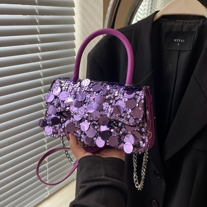 Detailed view of a purple sequined handbag with silver chain strap and top handle