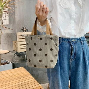 Detail of grey corduroy handbag with brown polka dots and durable canvas handles