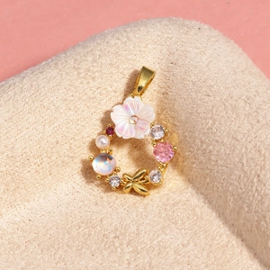 Macro view of gold flower pendant necklace with white petals and zircon accents