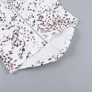 Close-up of floral camisole top featuring silver metal zipper and elastic waist detail