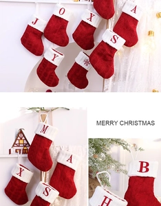 Detail of red cable knit Christmas stocking with white cuff and embroidered letter