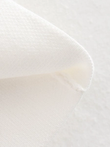 Gros plan sur le tissu en maille blanche montrant les coutures et la texture détaillée