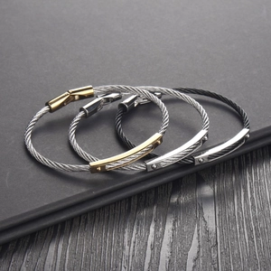 Close-up of twisted stainless steel cable bracelets with engraved metal magnetic clasps
