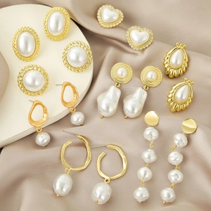 Close-up of vintage gold earrings with faux pearls and crystals on champagne silk