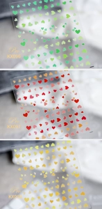 Close-up of gradient heart nail art stickers in green, pink, and gold KX series