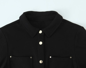 Détail de robe noire ajustée avec boutons dorés élégants et design col à revers