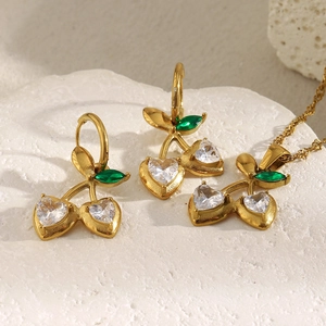 Golden cherry jewelry set with heart-shaped white crystals and green leaf details