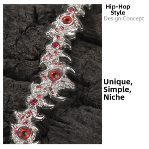 Detail of hip hop silver necklace featuring spiked thorns and a bold red gemstone inlay