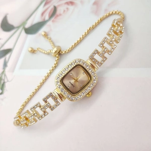 Detail of gold square quartz watch with rhinestones and adjustable drawstring chain strap