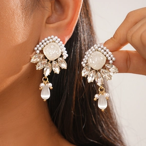Detailed view of vintage gold earrings with cat-eye stone, pearls and marquise crystals