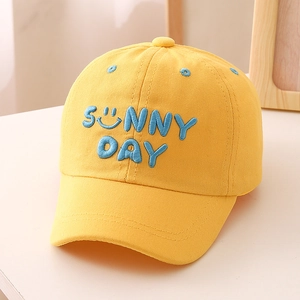 Close-up of sunny day blue embroidery and smile face on ginger cotton kids baseball cap