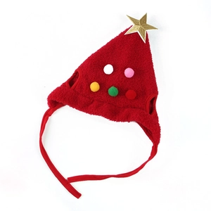 Detail of red plush Christmas dog hat with golden star and colorful pom-poms on top