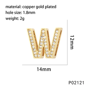 Detailed macro view of gold-plated letter W pendant with sparkling cubic zirconia stones