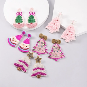 Detail view of handmade Christmas beaded earrings in festive holiday tree and star designs