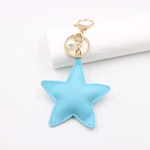 Detail of light blue PU leather star keychain with cross-grain texture and gold clasp