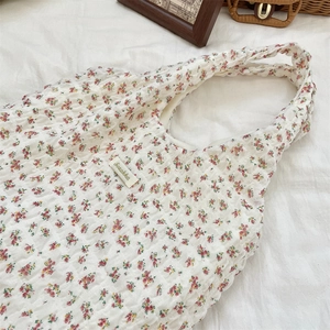 Detail of floral tote bag showing textured seersucker fabric and printed flower pattern