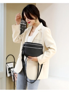 Detail of black leather crossbody bag featuring silver zippers and multi-layer design