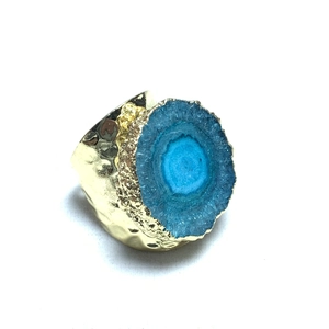 Detalle de la textura martillada bañada en oro de 14K y anillo de girasol con cristal azul