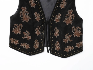 Vue détaillée de broderies florales bohèmes sur un gilet en velours noir à lacets