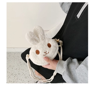 Detailed close-up of a white plush bunny crossbody bag worn by a child model
