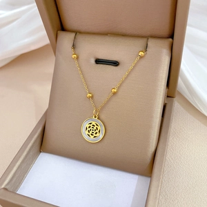 Elegant gold titanium steel necklace with camellia shell pendant in a jewelry box