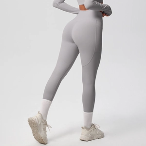 Detail view of grey high-waisted yoga leggings with functional side phone pocket