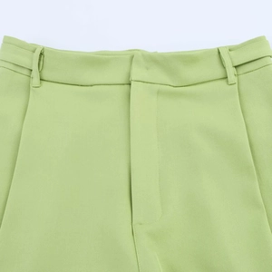 Détail de la taille du pantalon vert clair avec coutures nettes et texture en sergé