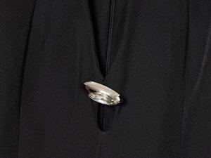 Détail de la fermeture éclair et de la boucle argentée avec cristaux sur la robe noire