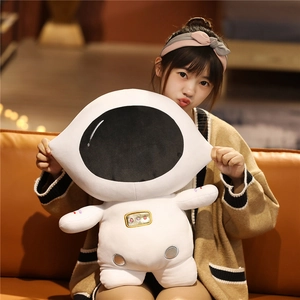 Soft astronaut plush toy featuring gold and silver embroidery details in a home setting