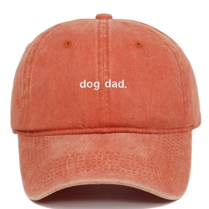 Macro view of white dog dad embroidery on vintage washed orange cotton baseball cap