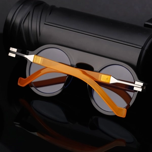 Detailed view of round sunglasses featuring amber tortoiseshell temples and metal hinges