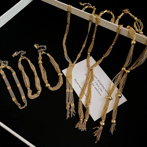 Golden multi-layer fringe necklace and bracelet set displayed in a premium jewelry gift box