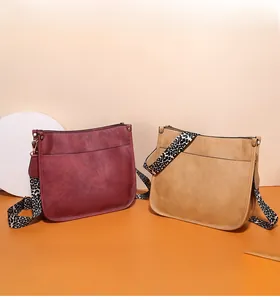 Detail of vintage PU leather tote bags in burgundy and tan with leopard print straps