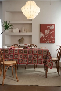Detailed view of red bohemian jacquard tablecloth with geometric patchwork patterns