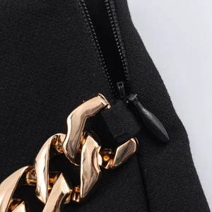 Detail der schwarzen Shorts mit goldener Gliederkette und verstecktem Reißverschluss