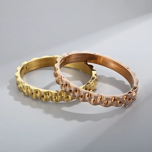 Détail des bracelets joncs à motifs ondulés en finitions or poli et or rose