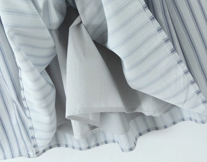 Detail view showing blue and white striped fabric texture and grey lining of the dress