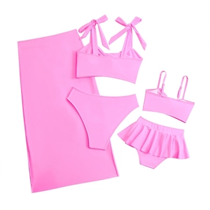 Detailed flat lay of bright pink parent-child bikini sets with matching sarong skirts