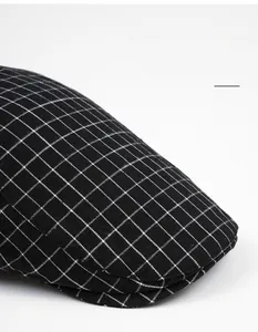 Close-up of the wide brim and black-and-white checkered texture of the flat cap