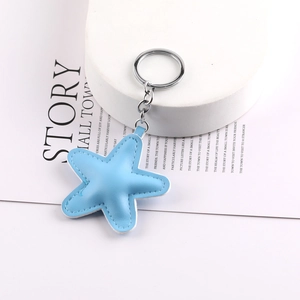 Blue leather star pendant with silver keychain ring and white stitching detail