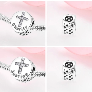 Macro shot of S925 sterling silver charms with Charity and Justice engravings and zircons