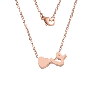 Detail of rose gold heart pendant with letter L on a polished stainless steel chain