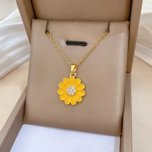 Detailed close-up of yellow daisy pendant with central rhinestone inlay on gold chain