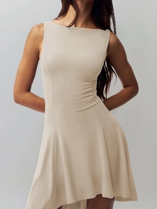 Close-up of sleeveless apricot dress with fitted waist and elegant draped fabric texture